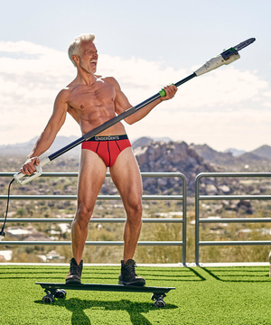 Underwear model in great red brief holding chainsaw on skateboard