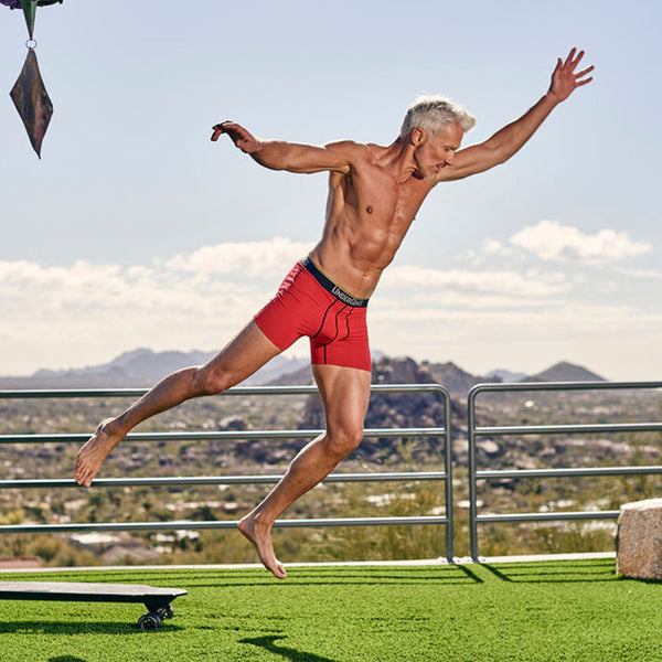 flying through the air in undergents men's red boxer brief