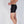 side view of 4.5 inch black boxer brief on white model who is thin. he feels the comfort of the leg skim instead of a leg squeeze